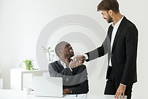 Caucasian employer congratulating black worker with promotion