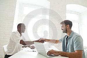 Caucasian employer meeting African American applicant with hands