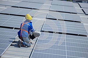 caucasian engineer checking on solar panel on the factory rooftop