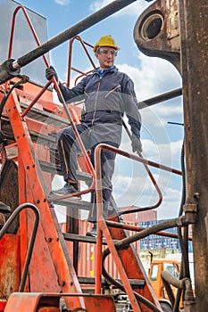 Caucasian engineer and heavy machine operator with container forklift at containers yard and cargo