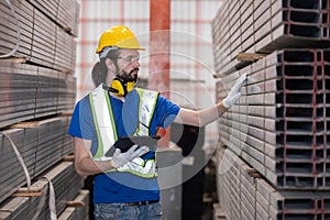 Caucasian engineer inspect steel bars with tablet in a factory