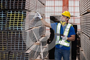 Caucasian engineer inspect steel bars with tablet in a factory