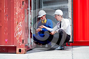 Caucasian engineer and technician  worker open container door and sit to check product also discuss together in workplace area