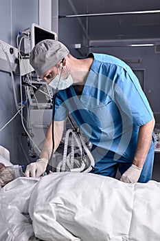 Caucasian experienced doctor putting stethoscope to senior patient, checking the heartbeat.