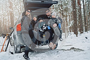 Caucasian family dressed in warm clothing in winter forest