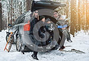 Caucasian family dressed in warm clothing in winter forest