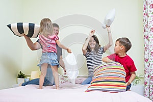 Caucasian Family of Four Having a Playful Funny Pillow Fight