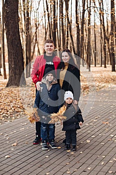 Caucasian family goes for a walk in the autumn park with two children