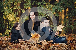 Caucasian family goes for a walk in the autumn park with two children