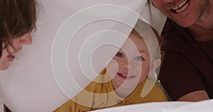 Caucasian family having fun in bedroom at home