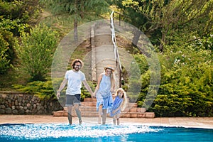 Family having fun their pool. family splashing water with legs or hands in swimming pool