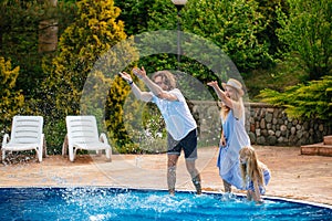 Family having fun their pool. family splashing water with legs or hands in swimming pool