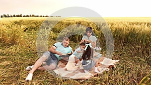 Caucasian family having picnic in a meadow at summer day in slowmo