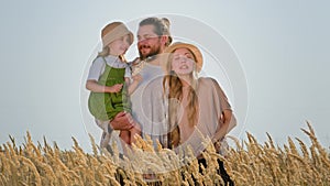 Caucasian family mother father with child girl parents with kid daughter bearded man and blonde woman in hat outdoors in