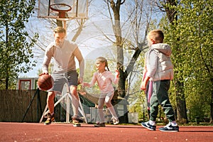 Caucasian family playing basketball together.