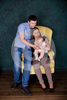 Caucasian Family Posing on Big Armchair in Studio