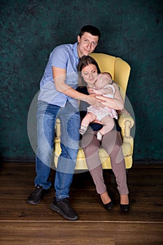 Caucasian Family Posing on Big Armchair in Studio