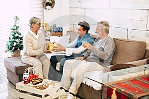 Caucasian family sharing gifts each other from grandfathers to grandson - senior to old generations together having fun in
