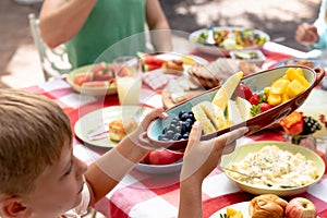 Caucasian family sitting at table during a family lunch in the garden