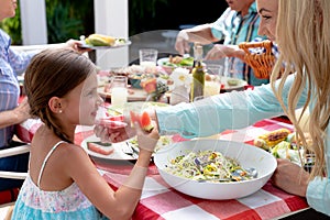 Caucasian family sitting at table during a family lunch in the garden