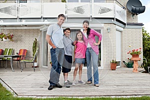 Caucasian family standing in front of house