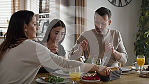 Caucasian family of three eating breakfast together.