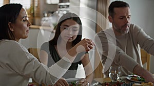 Caucasian family of three sharing breakfast food together.