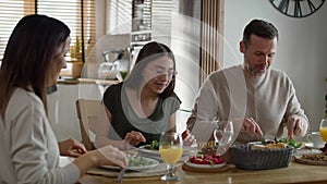 Caucasian family of three sharing breakfast food together.