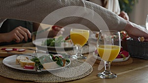 Caucasian family of three sharing breakfast food together.