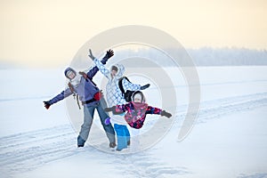 Caucasian family from three women standing with raising hands on lake, winter hiking