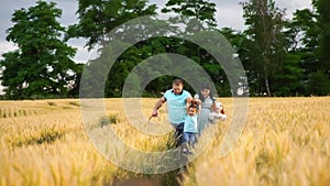 A caucasian family with two children walk in a summer field in slow motion
