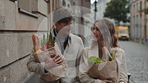 Caucasian family walking on street and carrying grocery bags