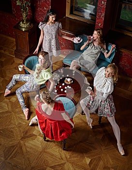 Caucasian fashion cheerful ballerinas in a pose drinking tea