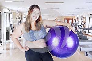 Caucasian fat woman holding a fitness ball