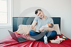 Caucasian father dad with newborn mixed race Asian Chinese baby working from home