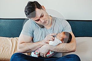 Caucasian father dad with newborn mixed race Asian Chinese baby working from home