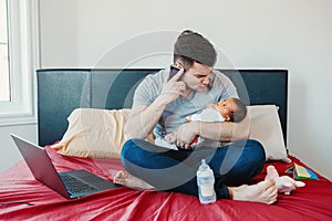 Caucasian father dad with newborn mixed race Asian Chinese baby working from home