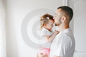 Caucasian father holding talking to toddler baby girl daughter