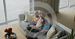 Caucasian father with two sons sitting in living room and using laptop