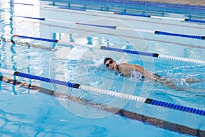 Caucasian female athlete swimmer swimming laps in a pool