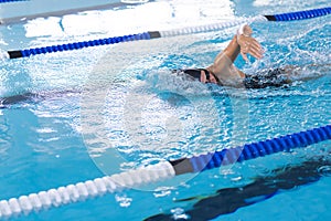 Caucasian female athlete swimmer swimming laps in a pool, with copy space