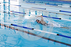 Caucasian female athlete swimmer swimming laps in a pool