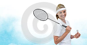 Caucasian female badminton player holding racket smiling against watercolor texture blue background