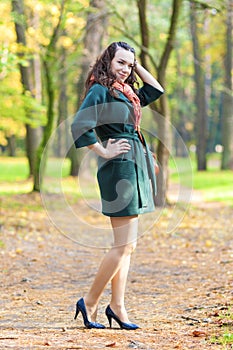 Caucasian Female Brunette Model Posing in Autumn Forest and smiling.