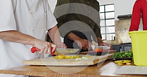 Caucasian female chef teaching diverse group wearing face masks