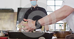 Caucasian female chef teaching diverse group wearing face masks