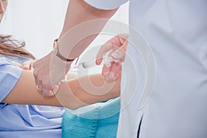 Caucasian female doctor injecting syringe,woman patient lying on bed in hospital ward,concept good health care insurance and