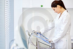 caucasian female doctor push buttons on medical equipment