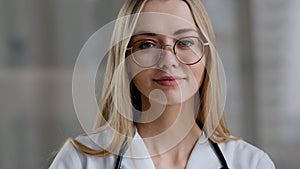 Caucasian female doctor wear eyeglasses make online video call in hospital clinic consult patient remote distant