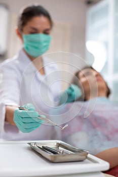 Caucasian female doctors hands holding a mouth mirror